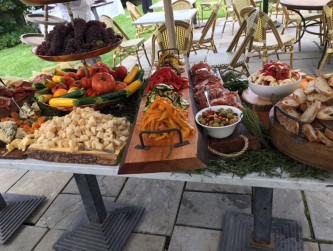 Tuscan Table with cheeses, meats, breads, veggies for cocktail hour on the patio